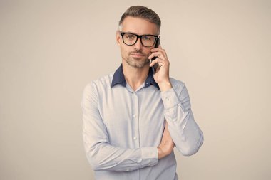 İş iletişimi. İş adamının Grey 'den izole edilmiş bir telefon görüşmesi var. Telefon kullanan bir iş adamı. Gözlüklü bir adam telefonda konuşuyor. Telefonu olan olgun bir iş adamı. Meşgul sinyali.