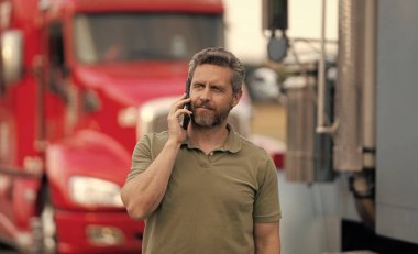 Kamyon şoförüne telefon var. Kamyon sahibi. Nakliye araçları. Kamyonetin önünde poz veren İspanyol bir adam. Yarı kamyon aracı. Kamyon şoförü. Kamyonetin yanında telefonla konuşan bir adam var..