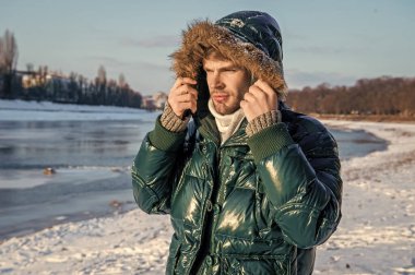 Adam kışın başlık giyerek üşür. Soğuk kışlı bir adam ceket giyer. Soğuk kışın ortasında bir adam. Kışın açık havada şık bir adam..
