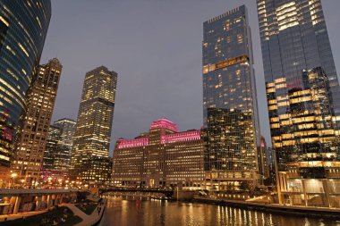 Şehir gecesi aydınlatılmış bina. Gökdelen şehir manzarası. Chicago 'nun gece şehri. İş şehri. Chicago gökdelen binasının gece manzarası. Chicago gökdelenin mimarisi. Işıklı köprüler.