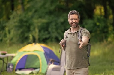 Yaz kampı ve doğa tatili. Yaz kampındaki adam. Kamp macerası. Yürüyüş konsepti. Kamp çadırı. Ormanda çadırda çadırda bir adam var. Bir yaz günü doğa yürüyüşçüsü. Reklam..