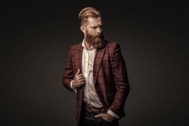 Bespoke takımı. Özel dikim erkek giysisi giymiş sakallı adam. Özel dikim kıyafet giyen bir iş adamı. Şık takım elbiseli bir iş adamı. Resmi terzilik kıyafeti. Erkek giyim kuşamı. Bohem stili.