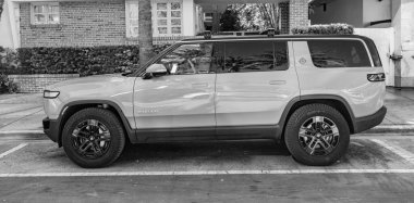 Miami Beach, Florida USA - 9 Haziran 2024 Rivian R1S Macera Motoru Miami plajında. Rivian R1S açık gri mavi