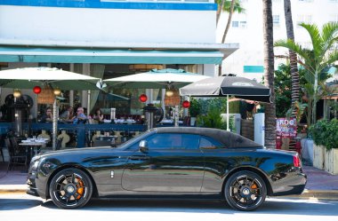 Miami, Florida, ABD - 06 Aralık 2024: 2017 Rolls Royce Dawn siyah araba. Lüks araba Rolls Royce Dawn. Araba siyahı Rolls Royce Dawn dışarıda park etmiş. Rolls Royce Dawn, yan görüş..