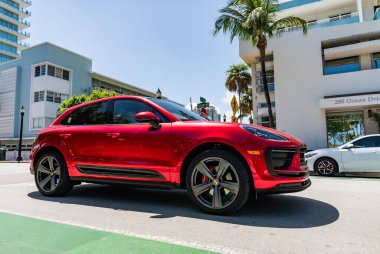 Miami, Florida, ABD - 06 Nisan 2025: Porsche Macan açık havada park etti. Kırmızı araba, yan görüş. Porsche Macan 2025 geçiş aracı. Lüks araba Porsche Macan..
