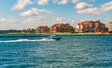 Fisher Adası Binası. Lüks motorlu tekne yatı. Yat marinaya gidiyor. Tekne ve yat gezisi. Lüks bir yaşam tarzı. Fisher Adası 'nda lüks bir binada yat. Yaz tatili. Romantik gün batımı.