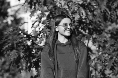 Sonbahar konsepti. Sonbahar tarzı açık havada bir kız. Sonbahar modası. Sonbahar yaprakları ve ormanda mutlu genç bir kız. Sonbaharın rengi ve havası. Sonbahar parkındaki genç kız. Sıcak günler.