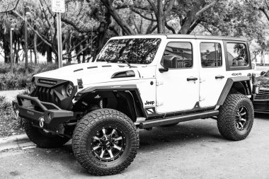 Miami Beach, Florida USA - 10 Haziran 2018 Jeep Wrangler Sınırsız Sahara 4x4 beyaz okyanus sürücüsü Miami plajı. Jeep yaygın bir arazi aracı markasıdır. Yan görünüş. beyaz.