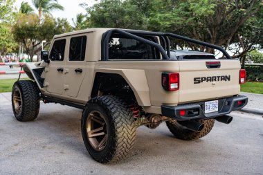 Miami, Florida, ABD - 06 Nisan 2025: kamyonet aracı Gladyatör. Araba Jeep Gladyatörü Spartan dışarıda park etmiş. Bej kamyonet, alçak görüş. 2024 Jeep Gladyatörü kamyoneti ayarladı.