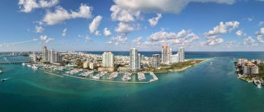 Miami silueti ve Biscayne Körfezi Panoraması. Kıyı gökdelenleri olan panoramik şehir manzarası. Miami Beach 'in yukarıdan manzarası. Drone Fisher Adası 'nı ve limanı ele geçirdi.