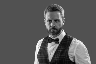 Yakışıklı garson adam smokin giyer. Şık smokin papyonu. Papyonlu garson servis yapmaya hazır. Garson. Smokinli erkek giysili adam Griler 'de izole edilmiş. Resmi erkek giyim sektöründe karizmatik bir adam. Boşluk afişini kopyala.