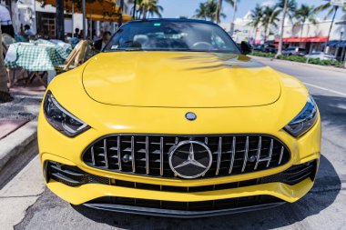 Miami, Florida, ABD - 19 Nisan 2025 Sarı araba, ön manzara. Mercedes Benz SL R232 üstü açık spor araba. Üstü açık Mercedes Benz SL R232. Mercedes Benz SL R232 dışarıda park halinde..