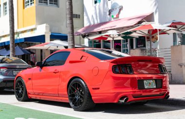 Miami, Florida, ABD - 12 Nisan 2025: 2014 Ford Mustang GT spor arabası. Lüks spor araba Ford Mustang GT. Araba Ford Mustang GT dışarıda park halinde. Kırmızı spor araba, köşe manzaralı.