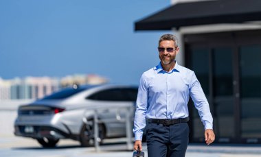 Açık havada başarılı bir iş adamı. Profesyonel iş adamı takım elbise giyer. İşadamı patron portresi. Başarılı bir iş. Başarı girişimci bayiliğinde. İş molasında ofis yöneticisi, afiş.