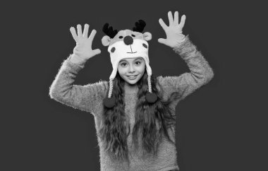 Kış çocuk kıyafetleri. Xmas şapkalı genç kız kırmızıda izole edilmiş. Gençler için kış modası. Kış mevsiminde örgü şapkalı bir kız. Çocukluk yaşam tarzı. Kulak misafiri modası.