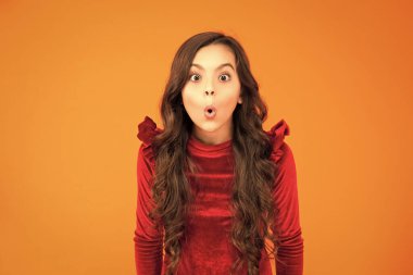 Şaşırmış suratlı kız turuncu üzerine izole edilmiş. Ne güzel bir sürpriz. Kıvırcık saçlı genç kız portresi. Genç kızlar duygularını gösterir. Vay kıvırcık saçlı. Kıvırcık saçlı genç kızın portresi. Şaşkınlık ifadesi..