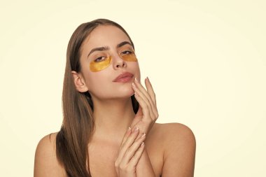 Yüz bakımı. Göz bandı takan bir kadın. Spa bakımı. Göz bandı. Göz altlarında kolajen pedleri olan güzel kadın yüzü. Kadının gözlerinin altında kolajen bantları olan taze ve sağlıklı bir cildi var. Günlük uygula.