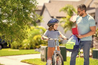 Baba oğluna ilk bisiklet sürüşünde rehberlik ediyor. Pedal çeviren ortaklar. Baba oğul bisiklet gezintisinin keyfini çıkarıyorlar. Baba ve oğul bisiklet macerasında. Baba ve oğul pedal çeviriyor resimli manzarada.
