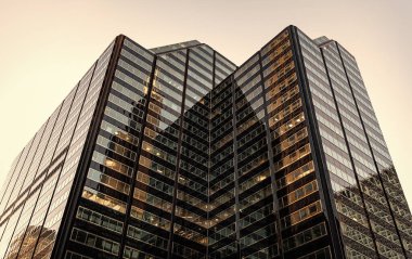 Şehir merkezinde gökdelenli. İş bölgesindeki ofis binası. Gökdelen mimarisi. Camdan yapılmış bir gökdelen. Modern bina. Şehir merkezindeki gökdelen. İş bölgesi.