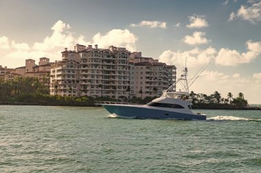 Lüks bir yaşam tarzı. Yaz tatilleri. Denizde yat. Yaz tatilinde deniz tatili. Fisher Adası Binası. Lüks tekne motorlu yat. Marinadan denize açılan lüks bir yat. Tekne ve yat gezisi.