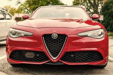 Chicago, Illinois - 29 Eylül 2024: 2017 Alfa Romeo Giulia kırmızı renk. 2017 Alfa Romeo Giulia sokağa park etmiş. 2017 Alfa Romeo Giulia ünlü İtalyan spor arabasıdır. ön görünüm