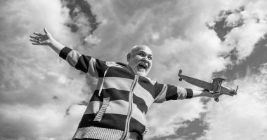 Gökyüzü geçmişindeki son sınıf öğrencisi şaşırdı. Emeklilikteki son sınıf. Dışarıda oyuncak uçağı olan yaşlı emekli bir adam..