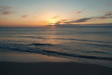 Yaz sahilinde deniz suyuyla güzel bir bali gün batımı..