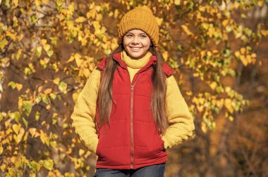 Sonbahar sezonunda okul zamanındaki pozitif genç çocuk.