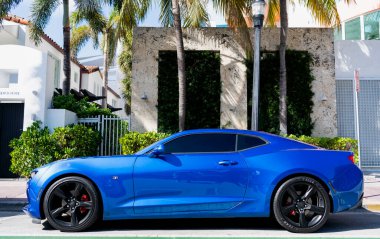 Miami, Florida, ABD - 11 Aralık 2024: 2016 Chevrolet Camaro Chevy metalik mavi araba. Lüks araba Chevrolet Camaro. Açık havada park etmiş metalik mavi Chevy Camaro. Chevrolet Camaro, köşe manzaralı..