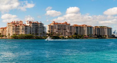 Marinaya yüzen bir tekne. Fisher Adası 'nda lüks bir yat teknesi. Yaz tatili. Fisher Adası konut binası ve lüks yat teknesi. Miami 'de Fisher Adası' na yat gezisi..
