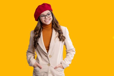 Şık bir sonbahar kızı sarıda izole edilmiş. Sonbahar beresi ve gözlük takan genç bir kız. Paltolu sonbahar kızı. Sonbahar ve sonbahar. Sonbahar sezonu. Sonbahar modası. Mevsimlik moda tarzı. Alan reklamını kopyala.