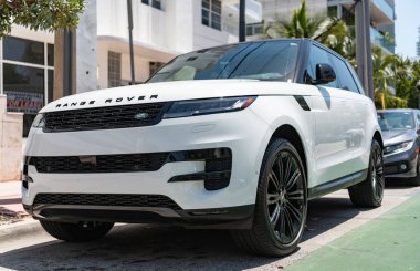 Miami, Florida, ABD - 21 Nisan 2025: 2025 Land Rover Range Sport lüks SUV arabası. Lüks arazi aracı Range Rover. Otomobil Range Rover 'ı dışarıda park etmiş. Beyaz SUV arabası, ön köşe manzaralı..