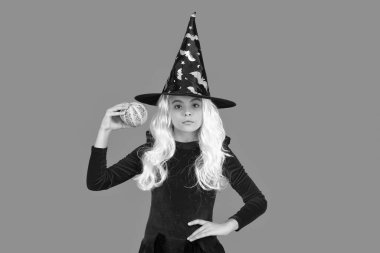 Cadılar Bayramı 'nda balkabağı. Cadıların Cadılar Bayramı kostümü. 31 Ekim balkabağı. Kostüm partisi. Cadılar Bayramı balkabağı cadı kızın elinde. Cadılar Bayramı cadısı, turuncu üzerine izole edilmiş. Balkabağı feneri..