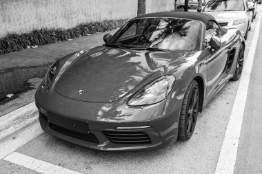 Miami Beach, Florida USA - 9 Haziran 2024: 2018 Porsche 718 Boxter 's orange color at Miami Beach. Ocean 'daki lüks araba porshche' si Miami plajına gidiyor. ön görünüm