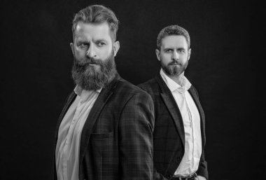 Smokin giyen şık takım elbiseli adamlar siyahta izole edilmiş. Erkek giyim bölümünde smokin giyen adamlar. Smokinli adamlar zarif ceket giyerler. Formalite içinde zarif erkekler. Zarafet ve tarz. İş etkinliğindeki iki iş adamı. Seçici odak.