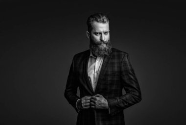 Bespoke takımı. Özel dikim erkek giysisi giymiş sakallı adam. Özel dikim kıyafet giyen bir iş adamı. Şık takım elbiseli bir iş adamı. Resmi terzilik kıyafeti. Erkek giyim kuşamı. Moda anlayışı.