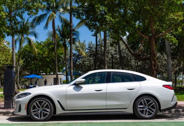 Miami, Florida, ABD - 02 Nisan 2025: 2024 BMW 4 Serisi Coupe Car. Üstü açık lüks BMW 4. Üstü açık BMW 4 arabası dışarıda park edilmiş. Beyaz üstü açık araba, köşe manzaralı..