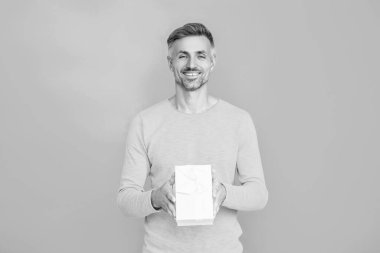 Adam Sevgililer Günü için hediye kutusu veriyor. Sevgililer günün kutlu olsun. Erkekler günü. Aşık bir adam maviden soyutlanmış. Randevu için romantik bir hediye. Erkekler günü için hediye. 14 Şubat 'ta olgun bir adam. Ürünü sunuyorum..