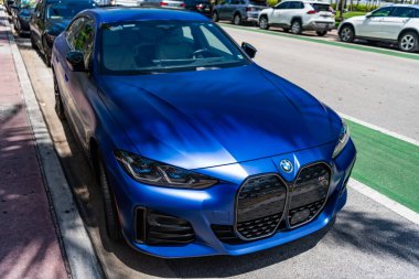Miami, Florida, ABD - 13 Nisan 2025: BMW i4 M50 2023 elektrikli araba. Lüks elektrikli BMW M50. Araba BMW i4 model M50 elektrikli açık hava parkı. Mavi elektrikli araba, yan görüş..