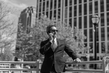 Takım elbiseli bir adam telefonda konuşuyor. Telefonu olan orta yaşlı İspanyol işadamı. İş iletişimi. İş adamının dışarıyı araması gerekiyor. Telefon kullanan bir iş adamı. Toplantı tutanakları.