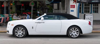 Miami, Florida, ABD - 4 Aralık 2024: 2016 Rolls Royce Dawn üstü açılabilir lüks Grand Tourer beyaz araba. Büyük turnuva arabası Rolls Royce Dawn. Araba Rolls Royce Dawn. Rolls Royce üstü açılır, yan görünüm.