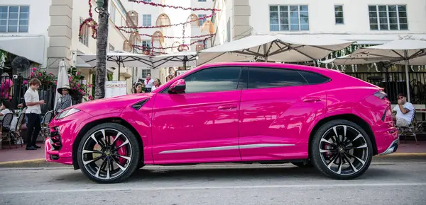 Miami, Florida, ABD - 02 Aralık 2024 Lamborghini Urus lüks SUV pembe araba. Lüks arazi aracı Lamborghini Urus. Araba siyah Lamborghini Urus dışarı park etmiş. Lamborghini Urus, köşe manzaralı..