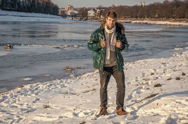 Adam kışlık ceket giyiyor. Açık havada kışlık ceketli bir adam. Açık havada kışlık ceketli şık bir adam. Tatillerde kışlık ceketli adam.