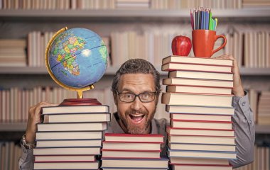 Sınıftaki kitap kurdu adam. Kitap edebiyatı öğretmeni. Okul kütüphanesinde eğitim. Adam kitap kurdu bilgi topluyor. Öğretmenler ve bilgi günü. Zeki öğretmen. merak dehası.