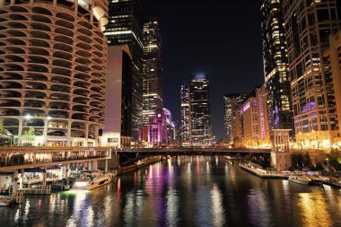 Gökdelen şehir manzarası. Chicago 'nun gece şehri. İş şehri. Chicago gökdelen binasının gece manzarası. Chicago gökdelenin mimarisi. Şehir gecesi aydınlatılmış bina. Lakefront parıltısı.