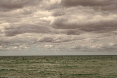 Deniz ufku manzarası. Bulutlu gökyüzü ve deniz manzarası. Deniz ufkuyla gökyüzü. Deniz doğasına sakin bir ufuk açısı. Deniz manzarasında bulutlu havada dramatik bir gökyüzü.