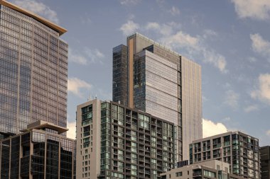Şehir merkezinde gökdelenli. İş bölgesindeki ofis binası. Gökdelen mimarisi. Camdan yapılmış bir gökdelen. Modern cam bina. Şehir merkezindeki gökdelen..