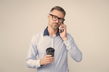 İş adamının Grey 'den izole edilmiş bir telefon görüşmesi var. Telefon kullanan bir iş adamı. Gözlüklü bir adam telefonda konuşuyor. Telefonu olan olgun bir iş adamı. İş iletişimi. Sesli mesaj..