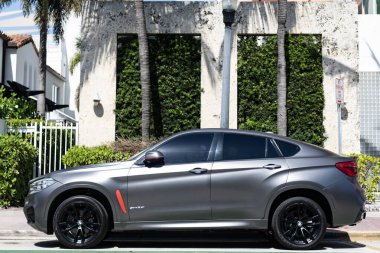Miami, Florida, ABD - 12 Nisan 2025: gri renkli cip arabası, yan görüş. BMW X6 2016 çapraz coupe SUV arabası. Çapraz SUV aracı BMW X6. BMW X6 otomobili dışarıda park halinde..