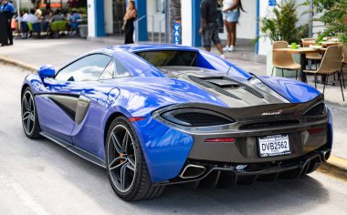 Miami, Florida, ABD - 19 Nisan 2025: Car McLaren 570 açık hava parkı. Mavi spor araba, dikiz aynası. 2018 McLaren 570 S spor araba. Lüks spor araba McLaren 570 'ler..